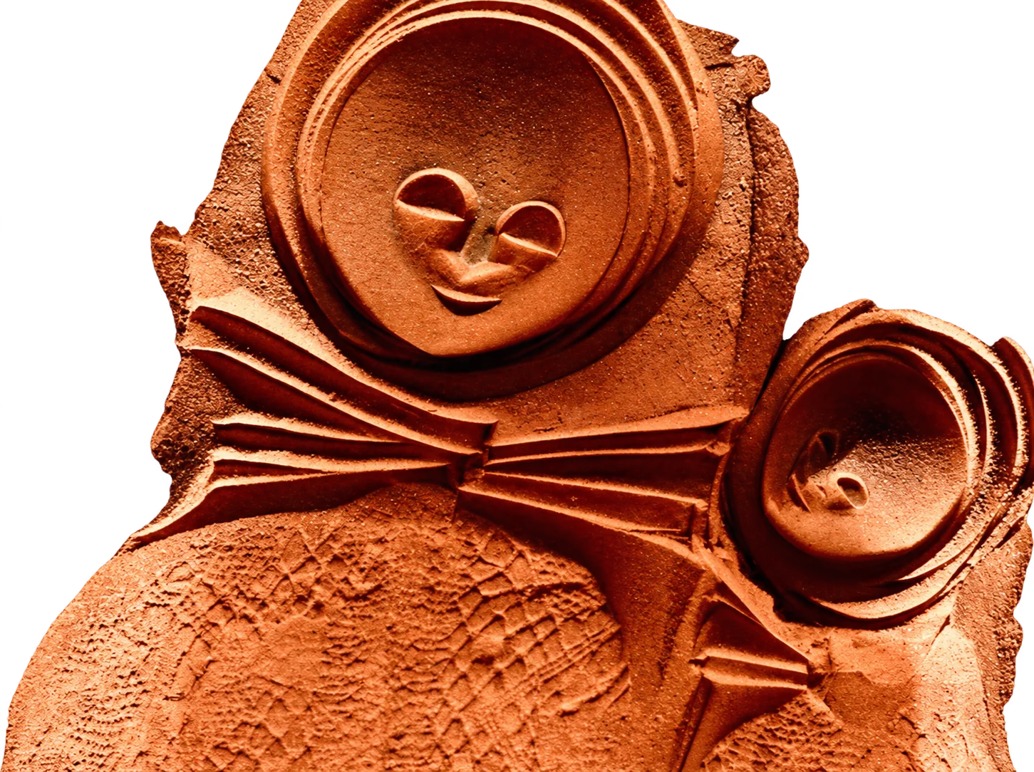 Gros plan sur une sculpture en terre cuite orangée montrant un grand visage souriant aux yeux fermés et un second plus petit, entourés de plis et de textures en relief.